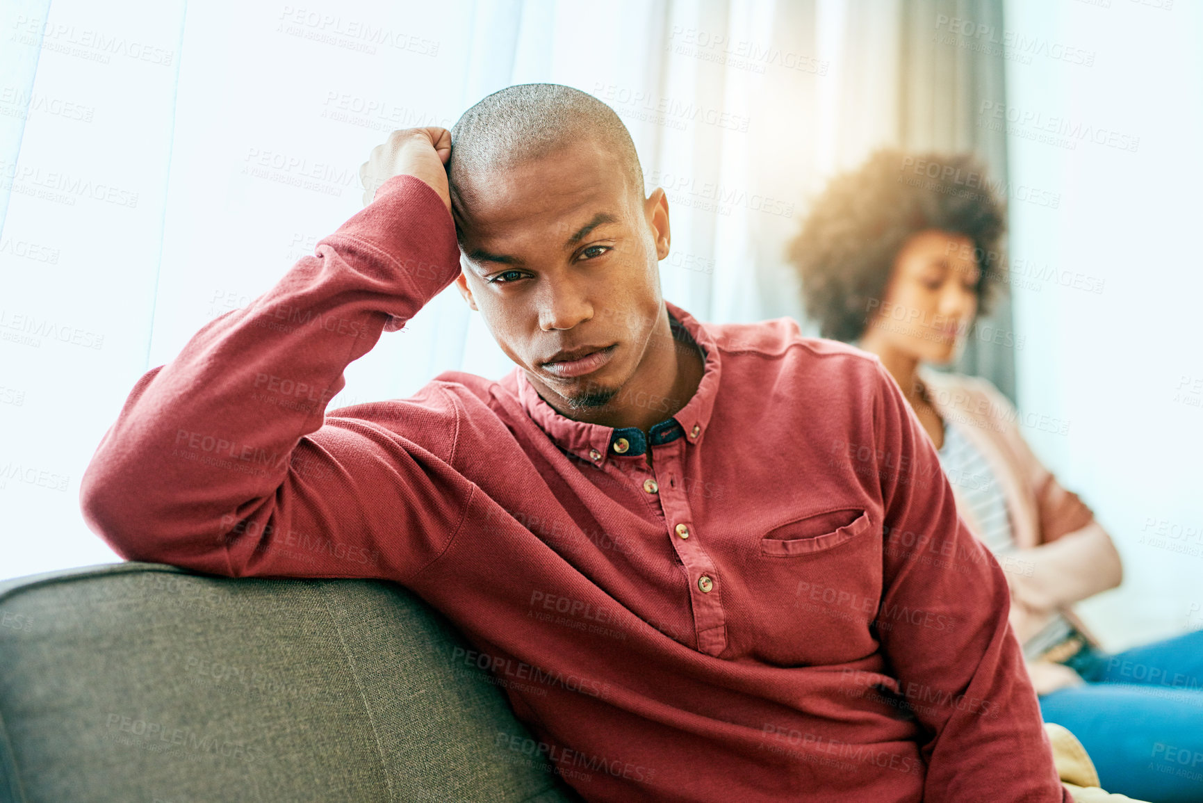 Buy stock photo Portrait of a young man looking upset after having a fight with his partner at home