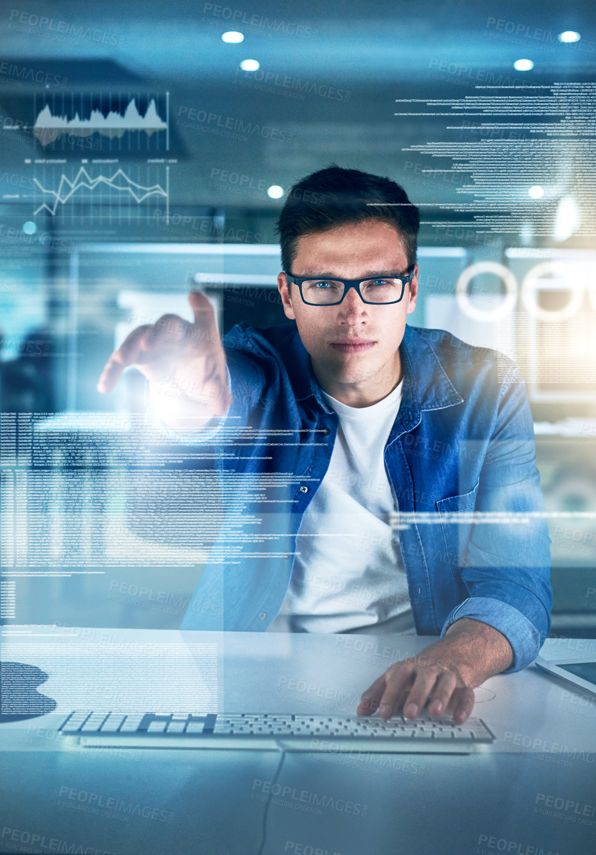 Buy stock photo Portrait of a focused young programmer working on his computer in the office during the night