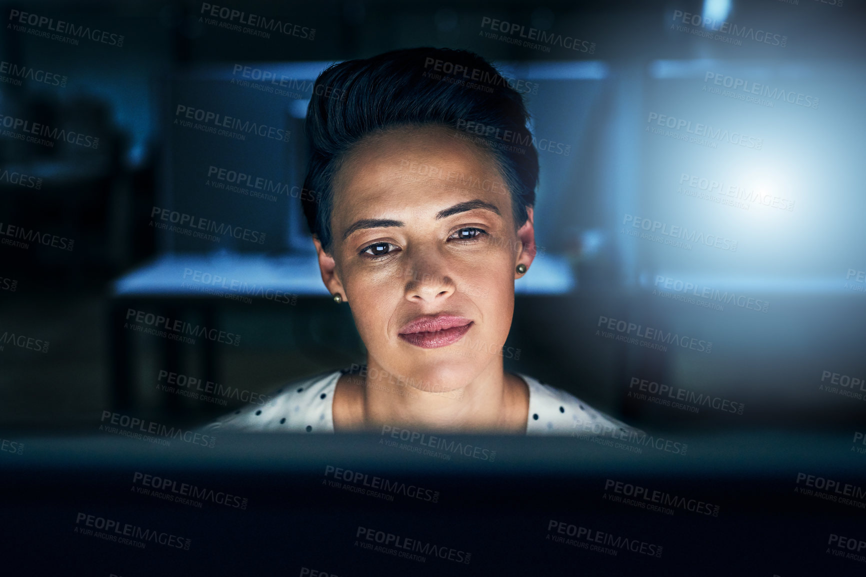 Buy stock photo Shot of a tired young female programmer working on a computer in the office at work during the night