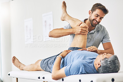 Buy stock photo Cropped shot of a young male physiotherapist assisting a senior patient in recovery