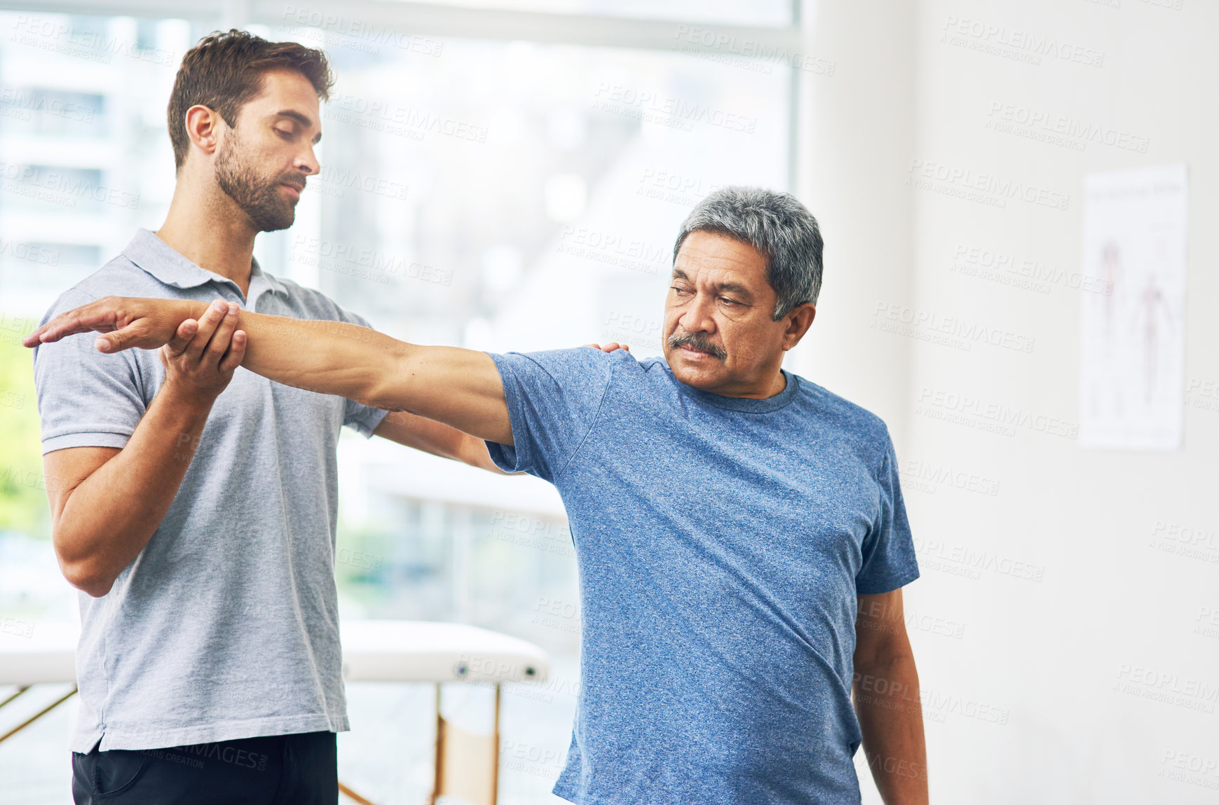 Buy stock photo Cropped shot of a young male physiotherapist assisting a senior patient in recovery