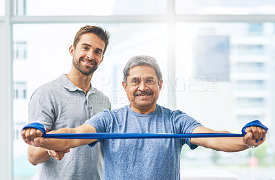 Buy stock photo Cropped portrait of a young male physiotherapist assisting a senior patient in recovery