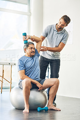 Buy stock photo Full length shot of a young male physiotherapist assisting a senior patient in recovery