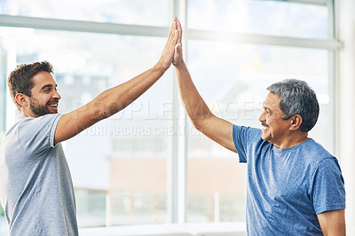 Buy stock photo Cropped shot of a young male physiotherapist and his senior patient high fiving after a great session