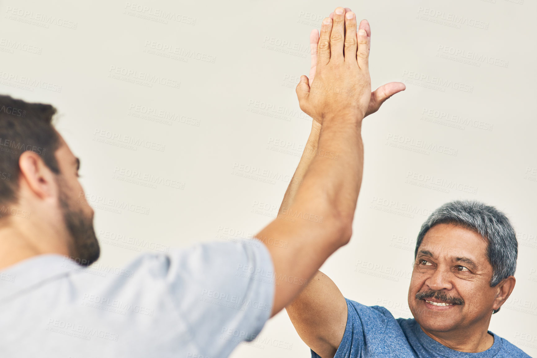 Buy stock photo Cropped shot of a young male physiotherapist and his senior patient high fiving after a great session