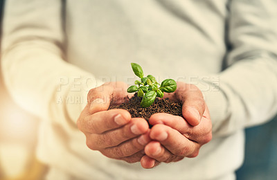 Buy stock photo Cropped shot of a businessman holding a plant growing out of soil