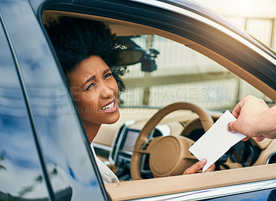 Buy stock photo Shot of a unhappy young businesswoman driving a car while receiving a parking ticket outside during the day