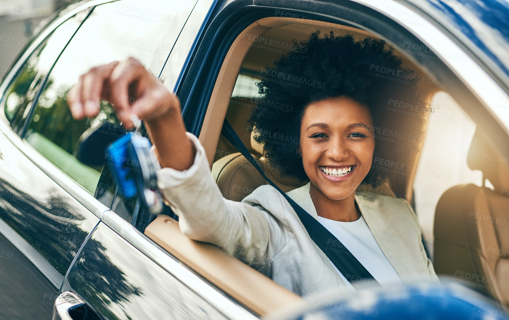 Buy stock photo Portrait of a cheerful young woman driving in her car to work while holding a set of keys during the day