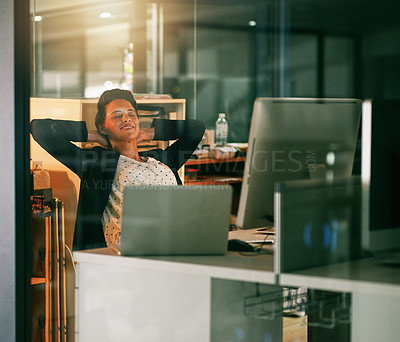 Buy stock photo Shot of a young businesswoman taking a break while working late in an office