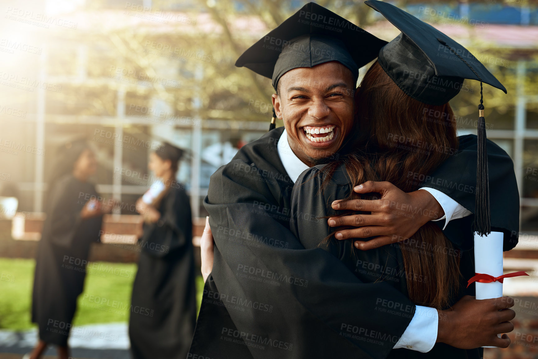 Buy stock photo Portrait of a happy young man and woman hugging on graduation day