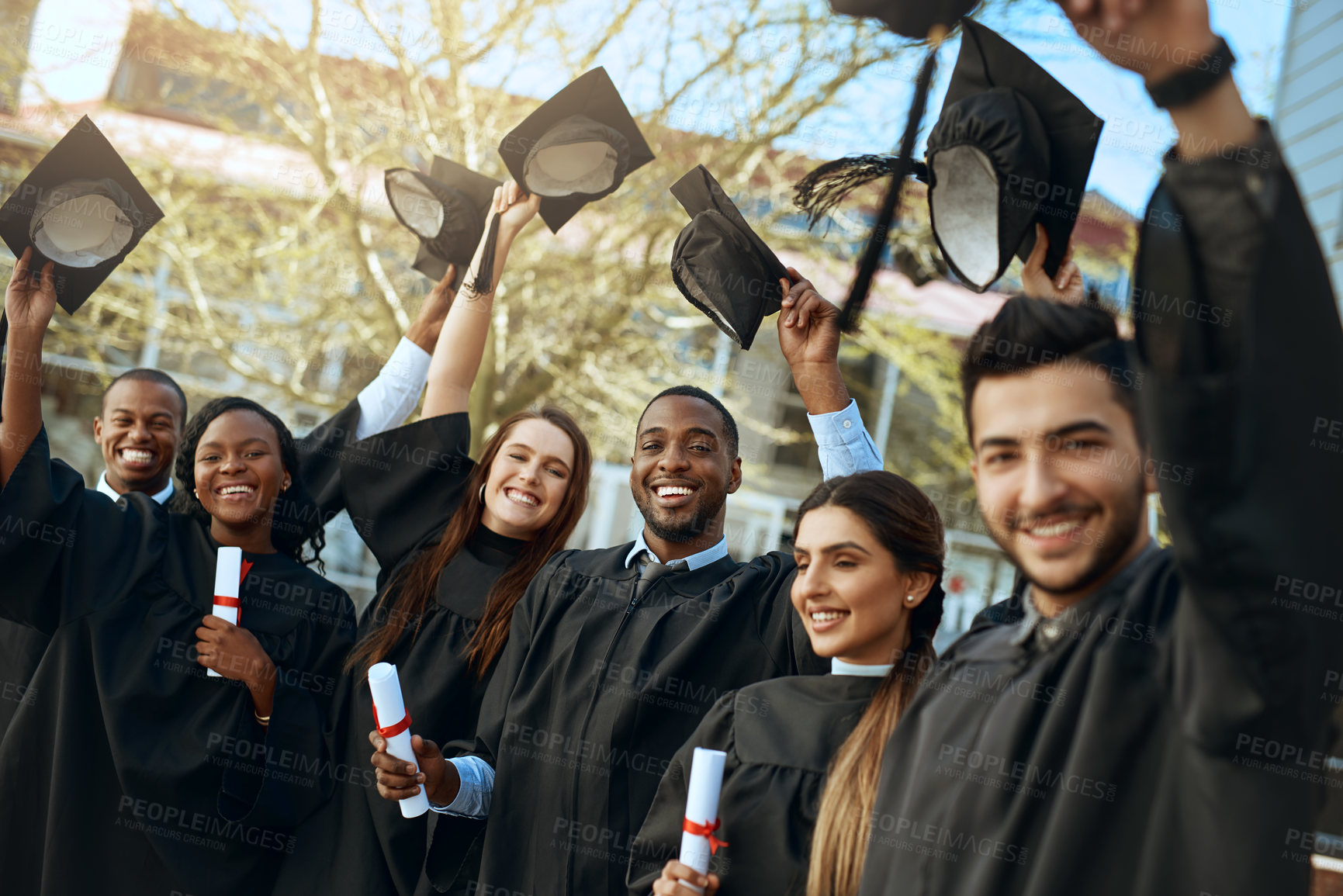 Buy stock photo Celebration, university and hats for group of graduates together with joy, graduation day and academic achievement outdoors. Education, young and students diversity in success and happy outside 
