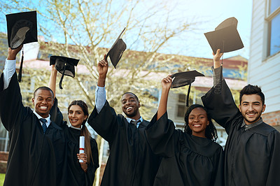 Buy stock photo Portrait of a group of happy young students taking their hats off on graduation day