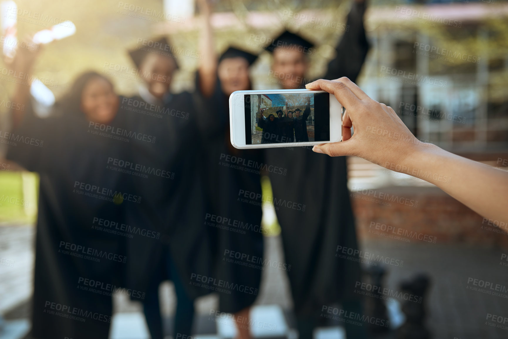 Buy stock photo Shot of a group of students taking pictures with a mobile phone on graduation day