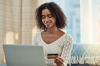 Buy stock photo Shot of an attractive young woman making payments online with a credit card at home