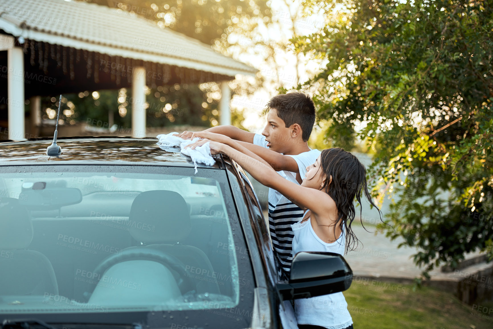 Buy stock photo Children, washing car and outdoor with cloth in garden, drying and shine with bonding, care and chores. Kids, brother and sister with cleaning, soap and help with wax for family vehicle in Spain