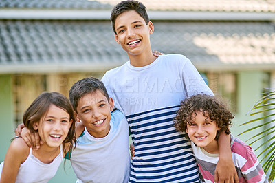 Buy stock photo Portrait of a group of happy siblings standing together in the backyard