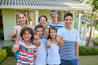 Buy stock photo Portrait of a happy multi generational family standing together in their backyard and giving thumbs up