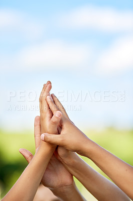 Buy stock photo Cropped shot of a group of children giving each other a high five outdoors