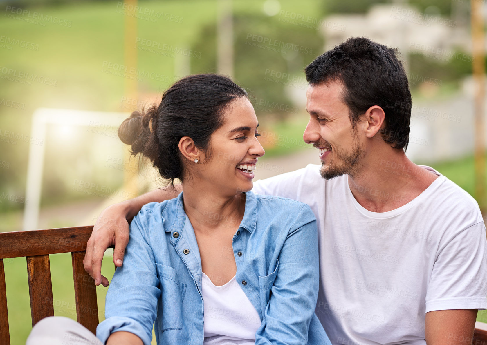 Buy stock photo Happy couple, hug and conversation with love on bench for date, holiday or outdoor weekend in countryside. Young, man and woman with smile in relax for romance, embrace or morning together on porch