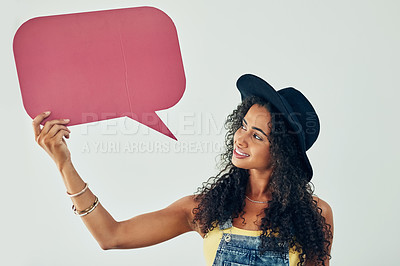 Buy stock photo Studio shot of an attractive young woman holding a speech bubble against a grey background
