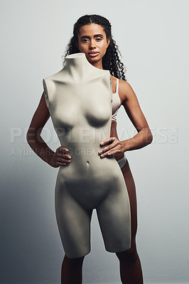 Buy stock photo Studio shot of an attractive young woman posing with a mannequin against a grey background