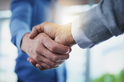 Buy stock photo Closeup shot of a two unrecognizable businessmen shaking hands in an office