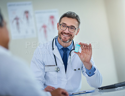 Buy stock photo Shot of a mature doctor prescribing medication to a patient in his office