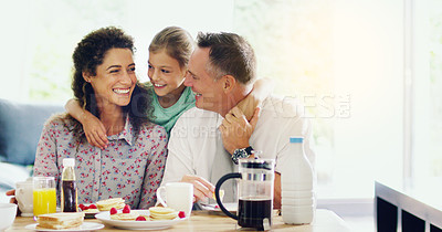 Buy stock photo Shot of a cute little girl having breakfast with her parents in the morning at home