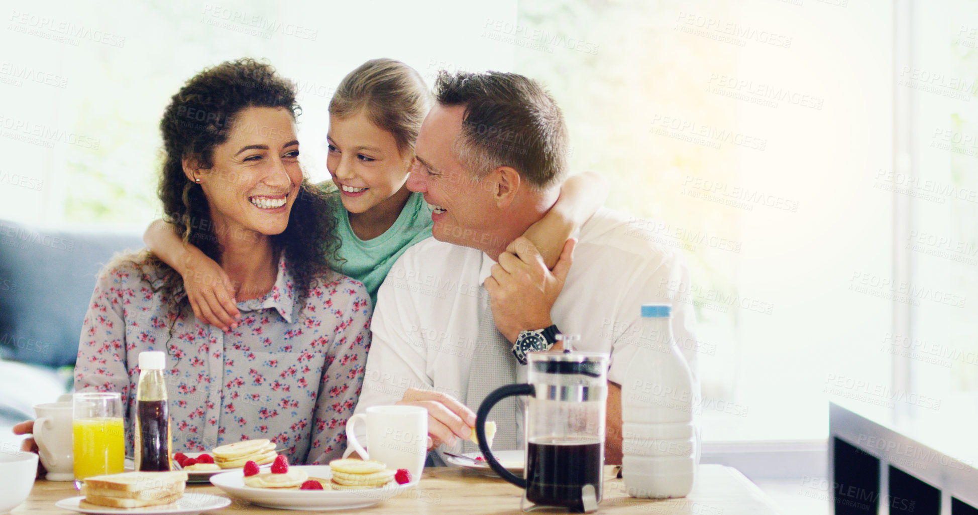 Buy stock photo Shot of a cute little girl having breakfast with her parents in the morning at home