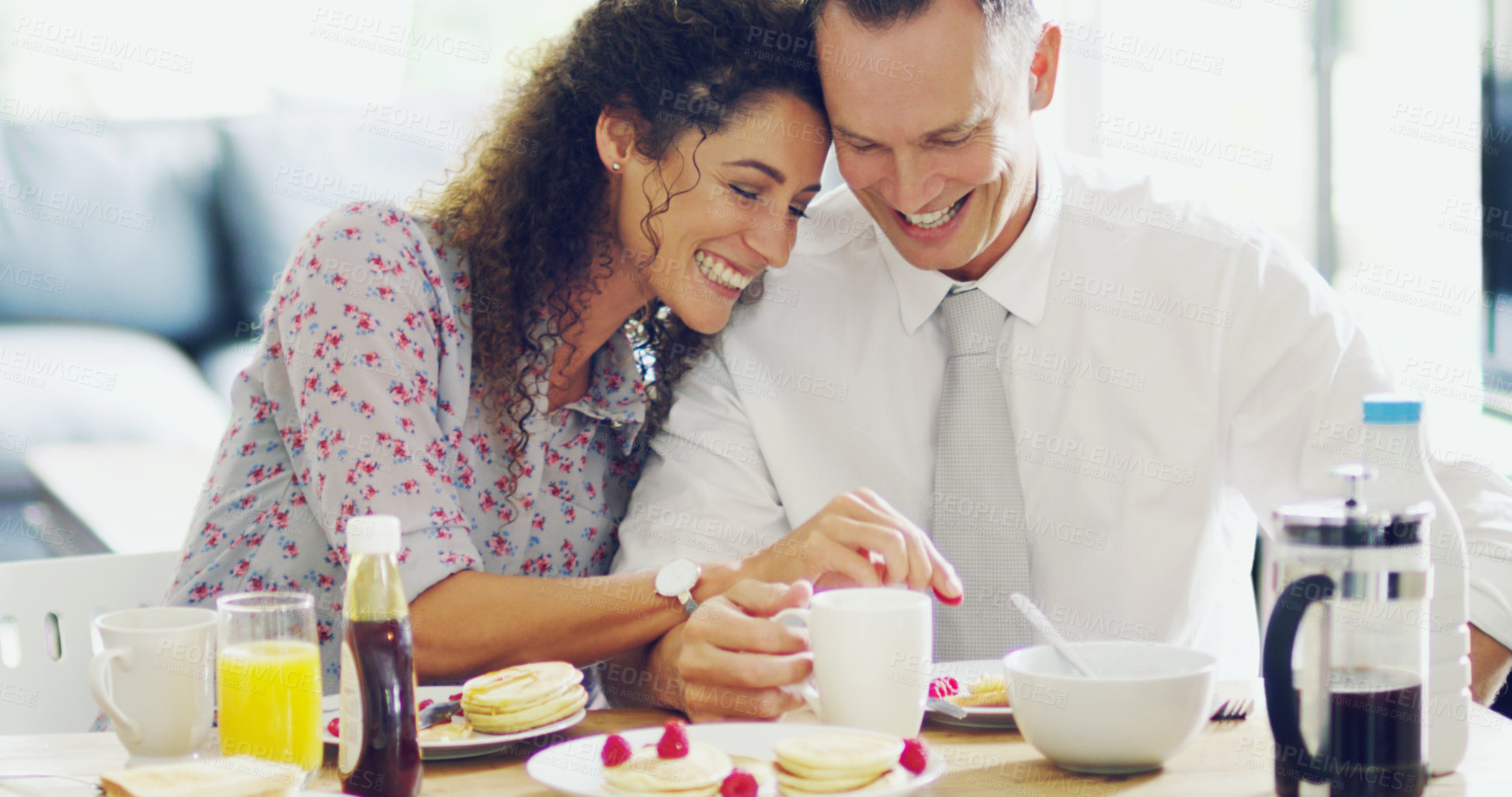 Buy stock photo Shot of an affectionate middle aged couple having breakfast together in the morning at home