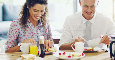 Buy stock photo Shot of a happy middle aged couple having breakfast together in the morning at home