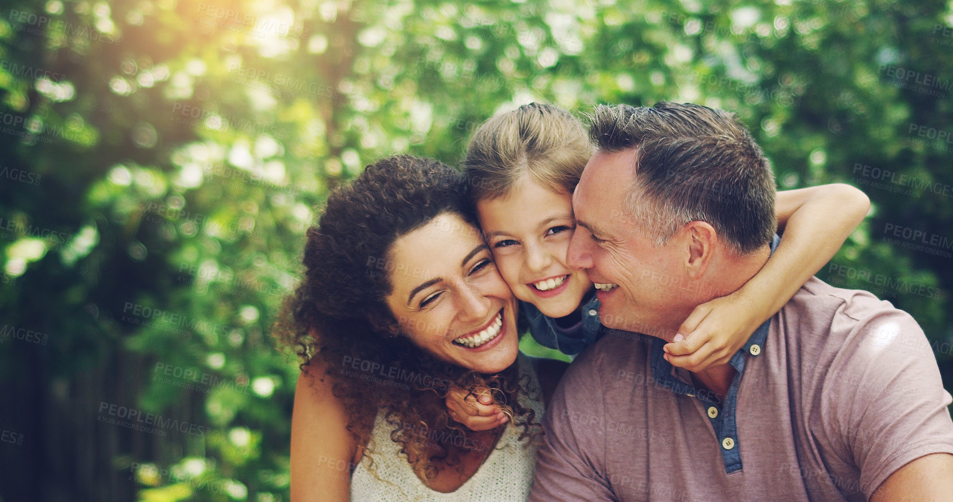 Buy stock photo Portrait of an affectionate little girl spending quality time with her mother and father outdoors