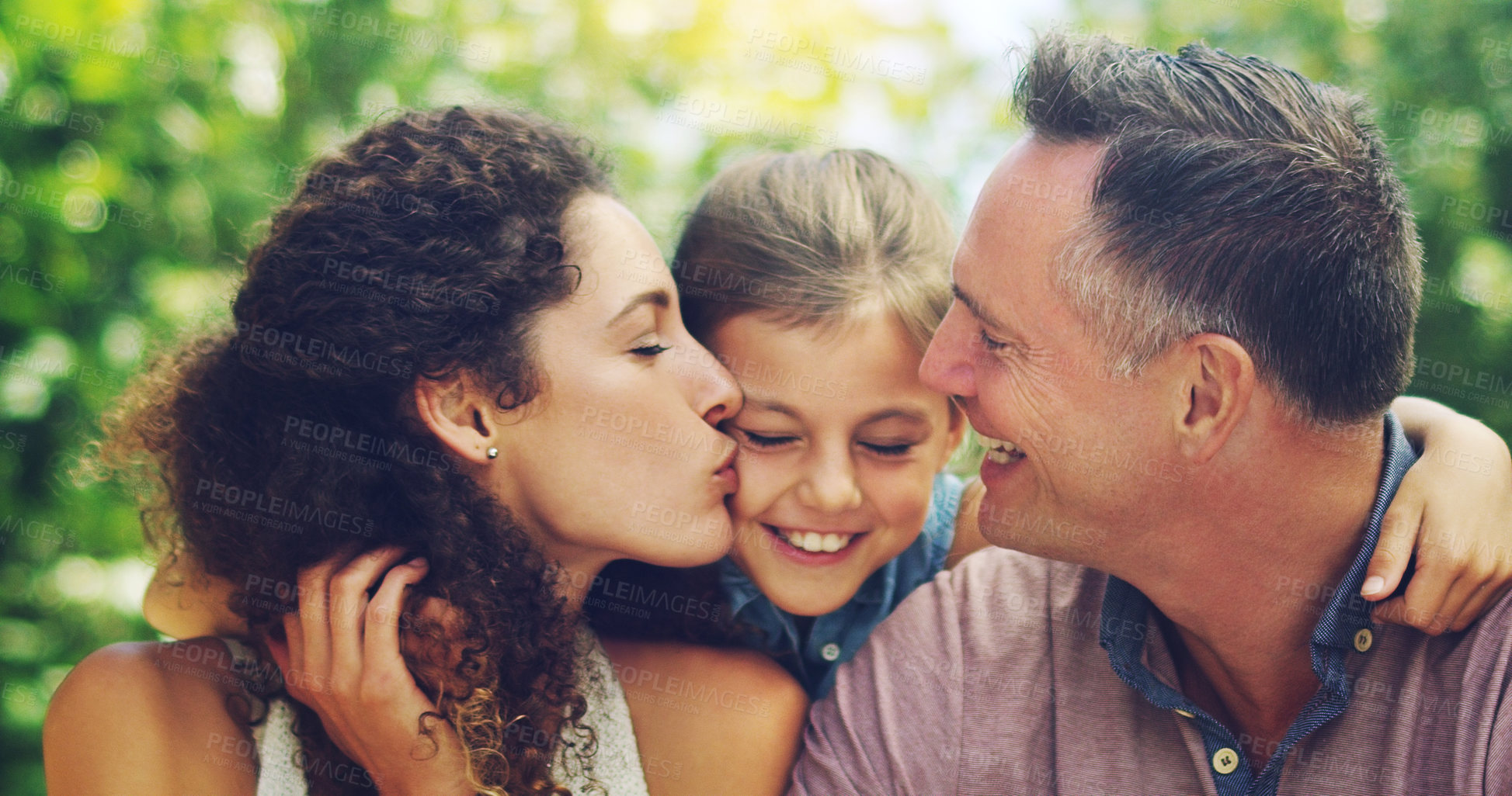 Buy stock photo Shot of an affectionate little girl spending quality time with her mother and father outdoors