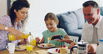 Buy stock photo Shot of a cute little girl having breakfast with her parents in the morning at home