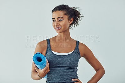 Buy stock photo Studio shot of an attractive young woman getting ready to practice yoga against a grey background
