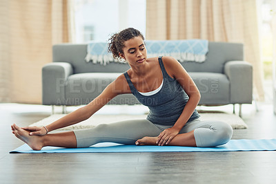 Buy stock photo Shot of an attractive young woman practicing yoga at home