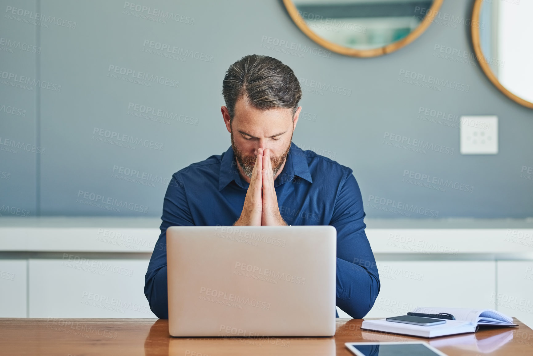 Buy stock photo Shot of a stressed out middle aged businessman working on his laptop while trying to think at home during the day