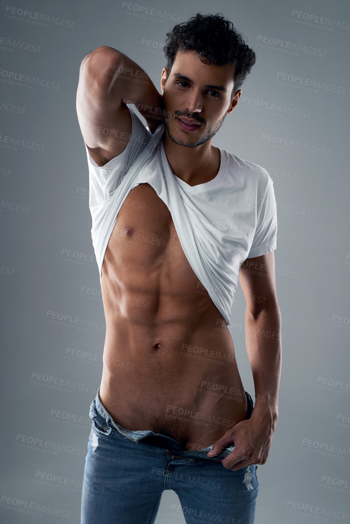 Buy stock photo Sexy, strip and portrait of man in studio with tshirt, confidence and sensual on gray background. Male stripper, audition and seductive for entertainment with abs, healthy body and casual fashion