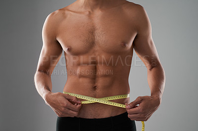 Buy stock photo Studio shot of an unrecognizable shirtless man measuring his midsection against a grey background