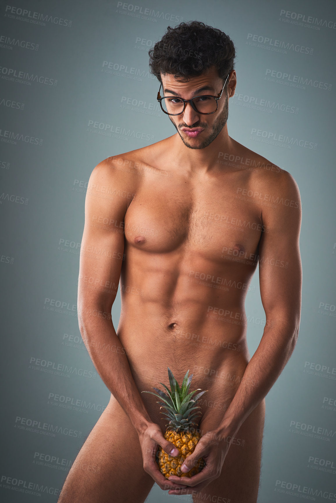 Buy stock photo Studio shot of a handsome young shirtless man posing against a grey background