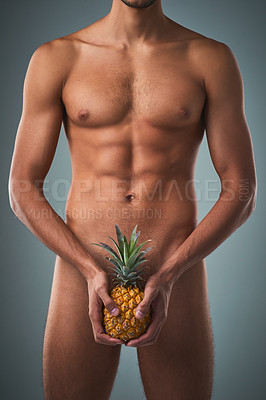 Buy stock photo Studio shot of an unrecognizable shirtless man posing with a pineapple against a grey background