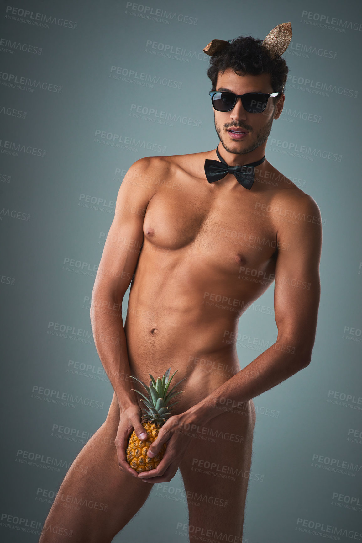 Buy stock photo Studio shot of a handsome young shirtless man posing against a grey background