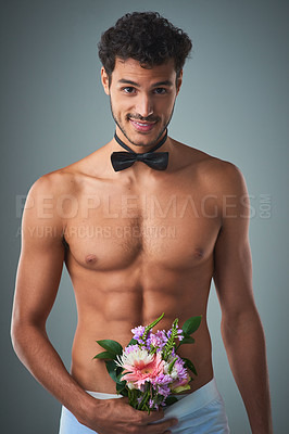 Buy stock photo Studio shot of a handsome young shirtless man posing against a grey background