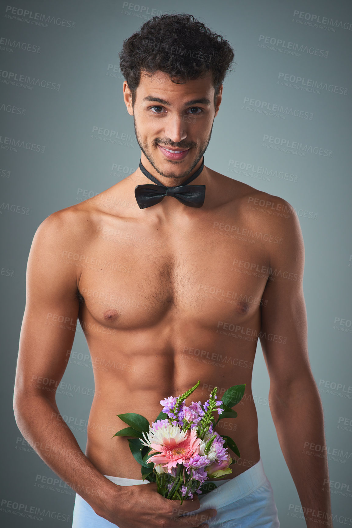 Buy stock photo Studio shot of a handsome young shirtless man posing against a grey background