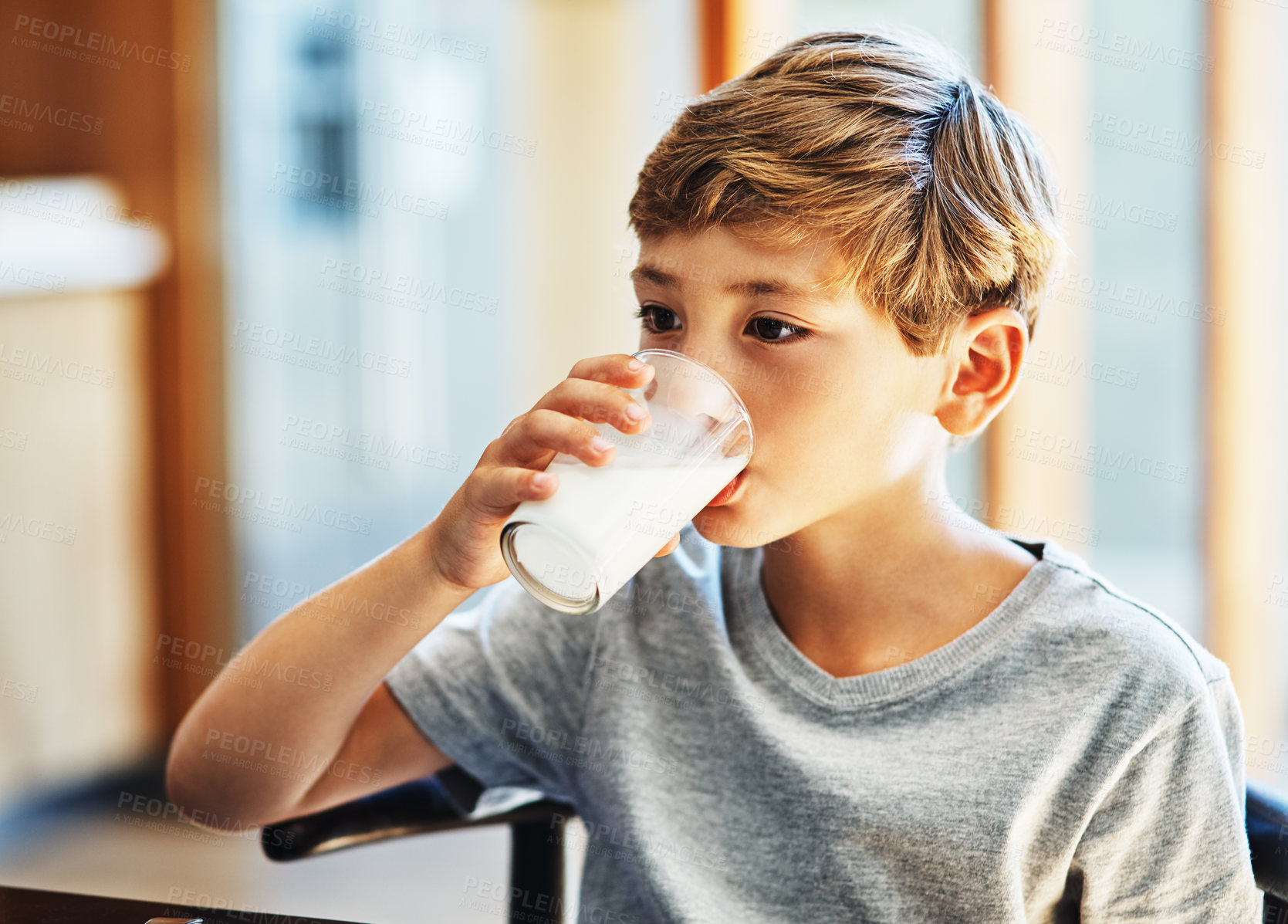 Buy stock photo Shot of a young boy drinking a glass of milk at home
