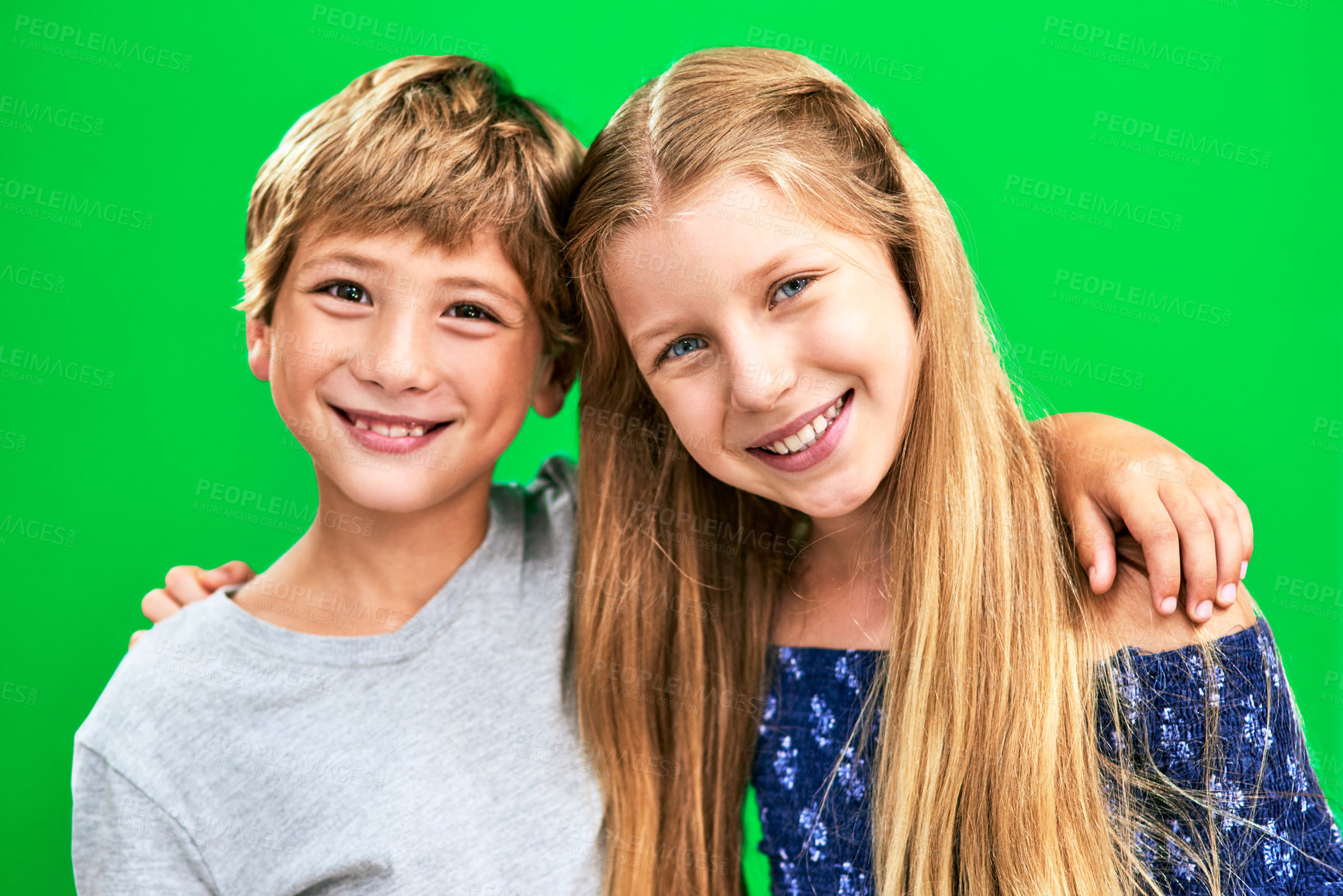 Buy stock photo Studio portrait of two adorable young children standing against a green background