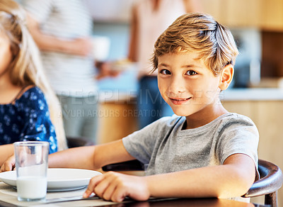 Buy stock photo Portrait of a young boy sitting at the breakfast table at home