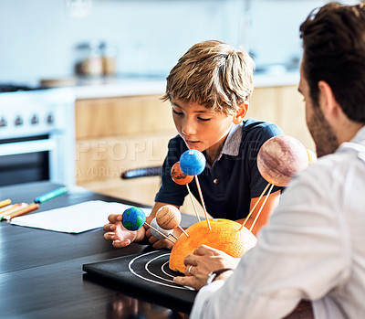 Buy stock photo Shot of a father helping his little son with a school project at home