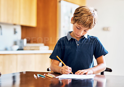Buy stock photo Shot of a young boy doing his homework