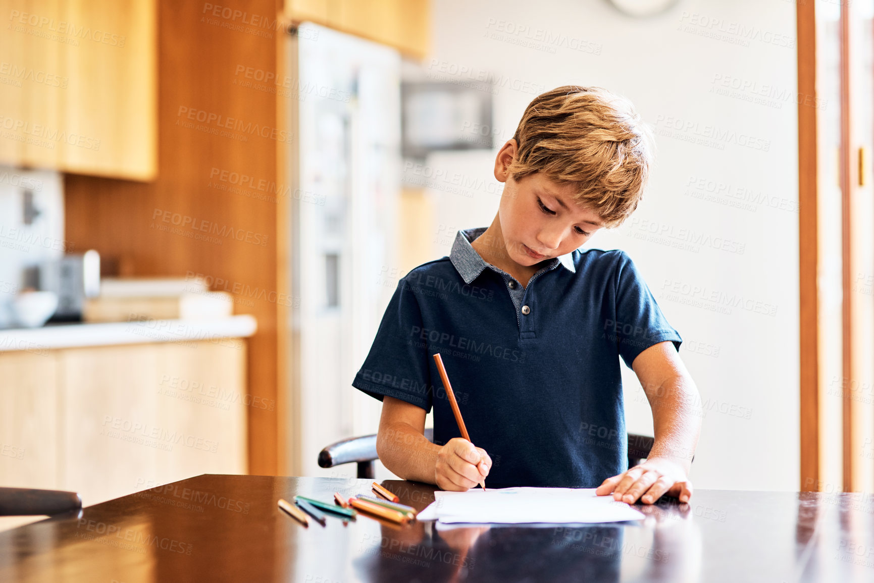 Buy stock photo Shot of a young boy doing his homework